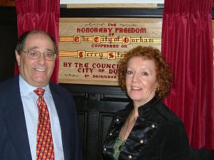 Gerry and Meg beside the plaque in the Town Hall