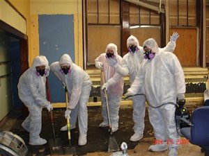 Suited workers removing asbestos