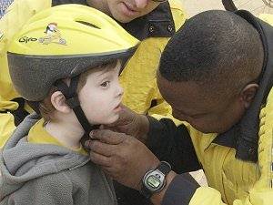 Child being fitted with a cycle helmet