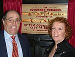 Gerry and Meg beside the plaque in the Town Hall